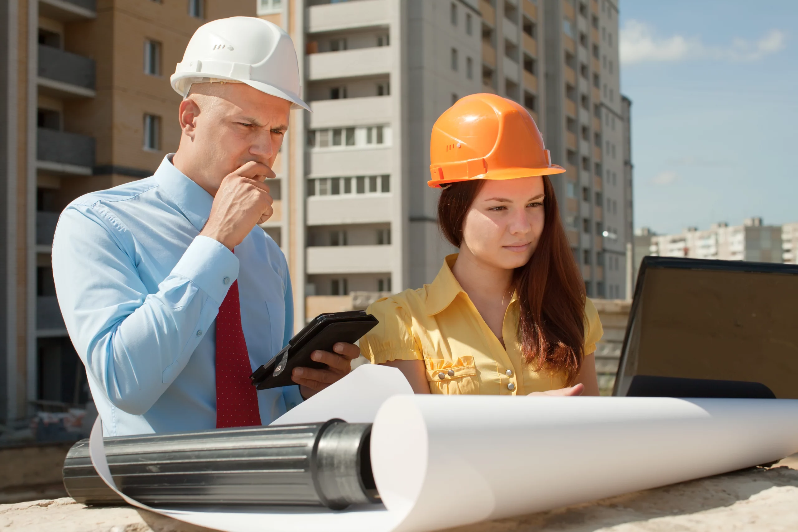 Deux artisans du bâtiment utilisant un logiciel de gestion sur un chantier